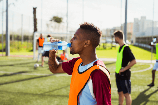 joueur de football en train de boire de l'eau sur le terrain